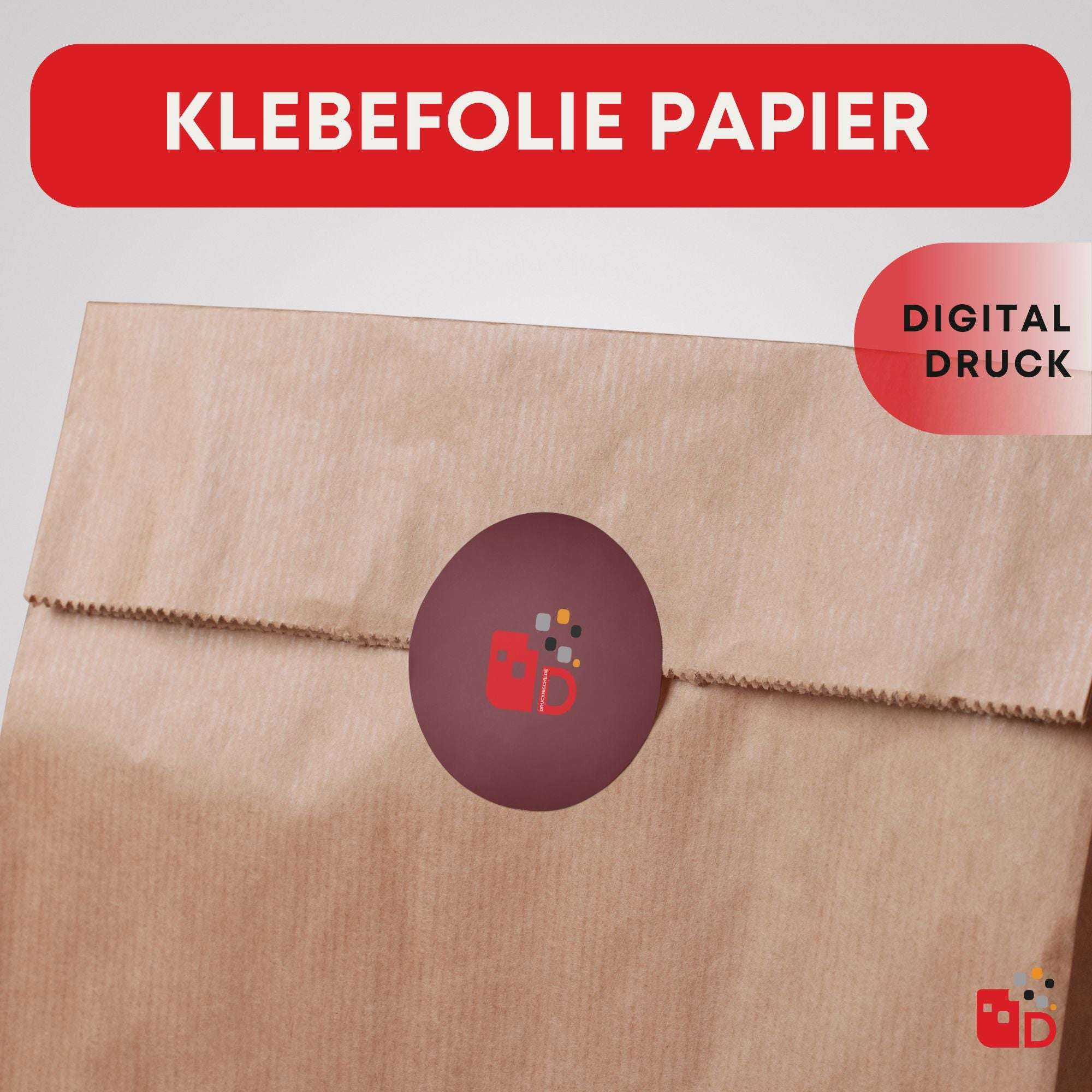 Braune Papiertüte mit rotem, rundem Aufkleber, der ein Logo zeigt. Oben steht: "Klebefolie Papier - Digital Druck".