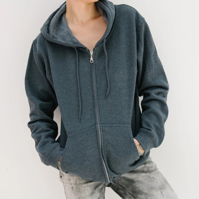 Ein dunkelgrauer Fleece-Hoodie mit Reißverschluss und Kapuze, kombiniert mit hellgrauen Jeans für einen lässigen, gemütlichen Look.